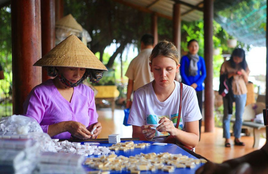 Turisti che preparano caramelle al cocco a Ben Tre