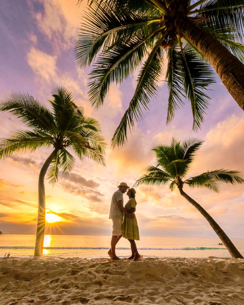 Una coppia al tramonto sulla spiaggia di Bang Tao a Phuket