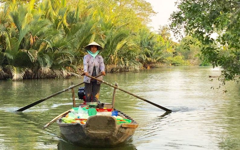 Donna su una barca nel Delta del Mekong